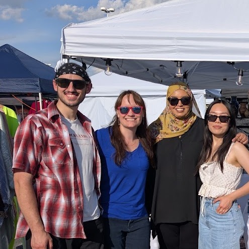 Kerima, Leigh, Ann, and Derek at a market booth